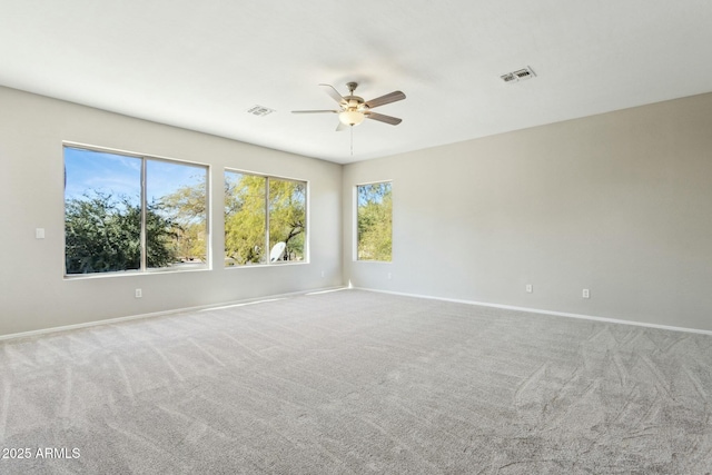 carpeted spare room featuring ceiling fan and plenty of natural light