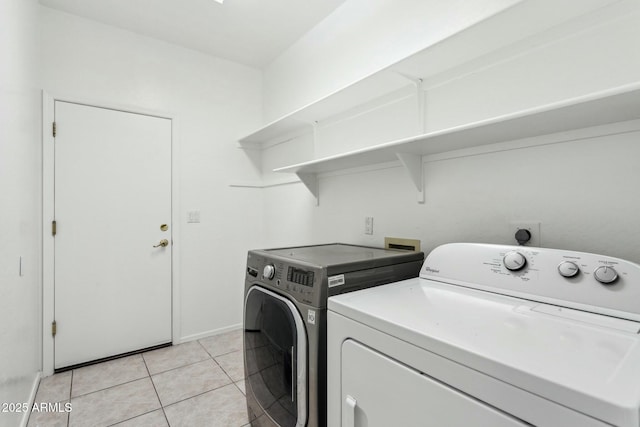 laundry area with light tile patterned flooring and separate washer and dryer