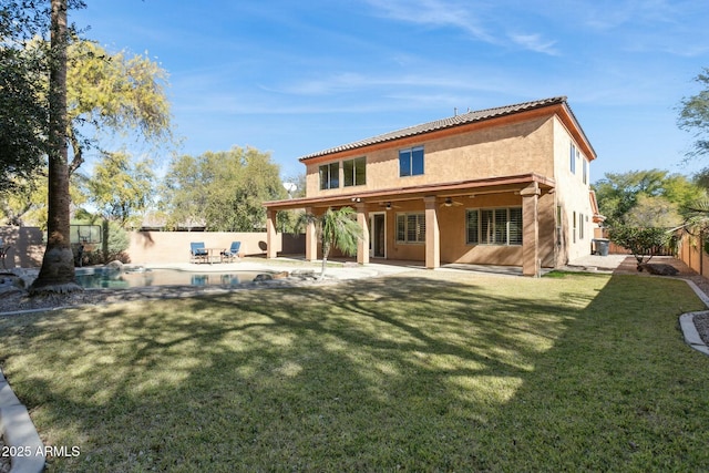 back of property with a fenced in pool, a yard, a patio area, and ceiling fan