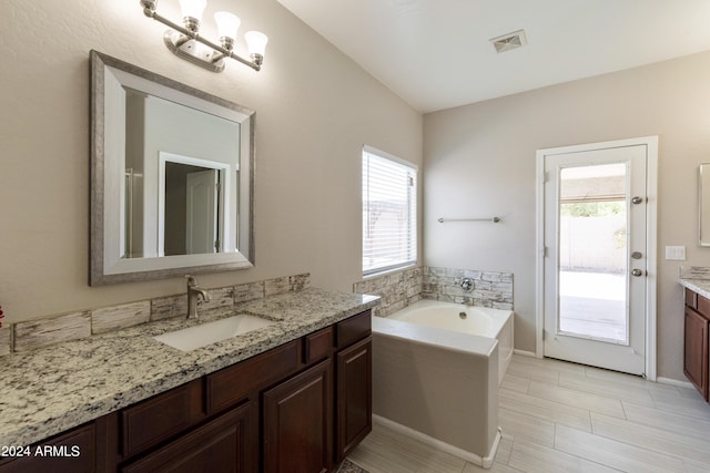 bathroom with vanity and a bath