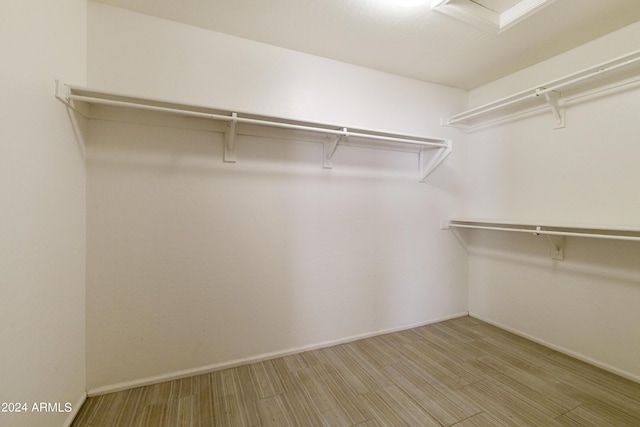 spare room featuring light colored carpet, vaulted ceiling, and baseboards