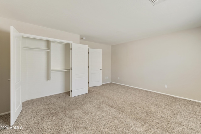 unfurnished room featuring baseboards, visible vents, and light colored carpet