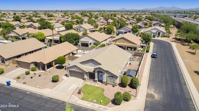 view of front of home featuring concrete driveway, a residential view, fence, a mountain view, and stucco siding