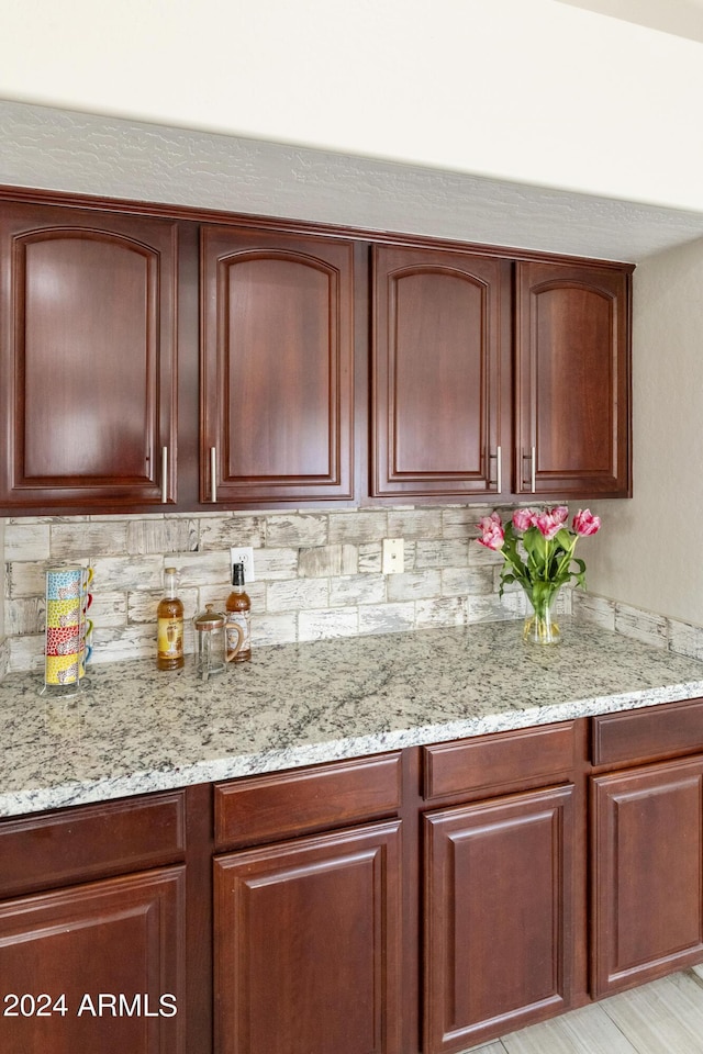 kitchen featuring dark brown cabinets and light stone counters