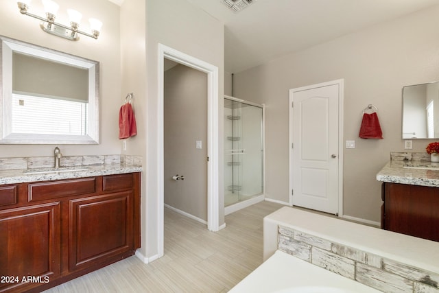 full bathroom with two vanities, a sink, baseboards, visible vents, and a shower stall