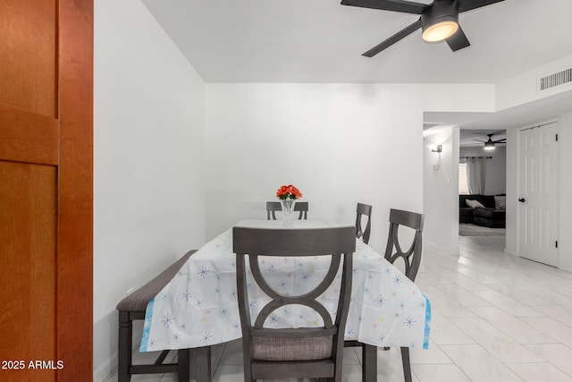 dining space featuring light tile patterned floors, ceiling fan, and visible vents