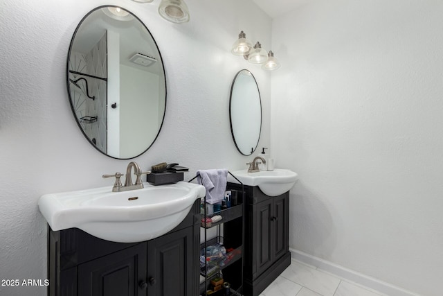 bathroom featuring two vanities, a sink, and baseboards