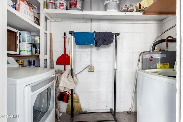 laundry room featuring concrete block wall, laundry area, and electric water heater