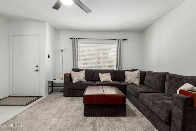 living room with ceiling fan and baseboards