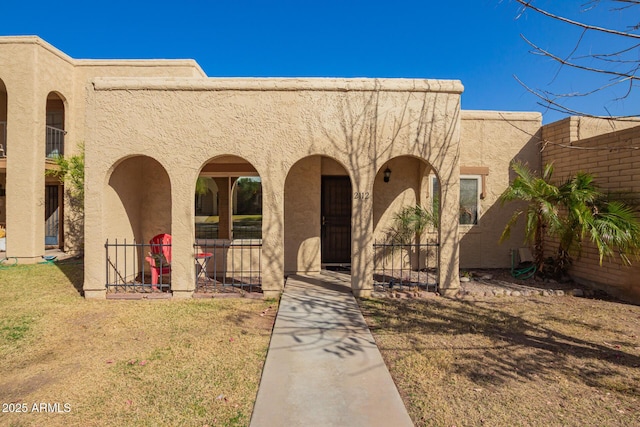 view of front facade featuring a front yard and stucco siding