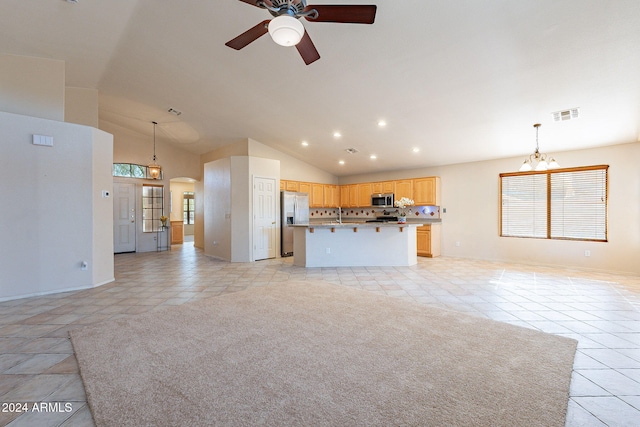 unfurnished living room with ceiling fan with notable chandelier, high vaulted ceiling, and light tile patterned flooring