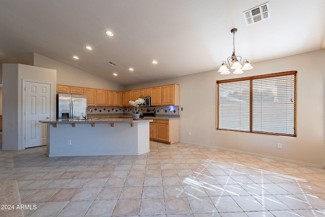 kitchen featuring a kitchen island with sink, hanging light fixtures, light tile patterned floors, tasteful backsplash, and stainless steel appliances