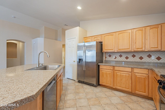 kitchen with tasteful backsplash, stainless steel appliances, vaulted ceiling, sink, and light tile patterned floors