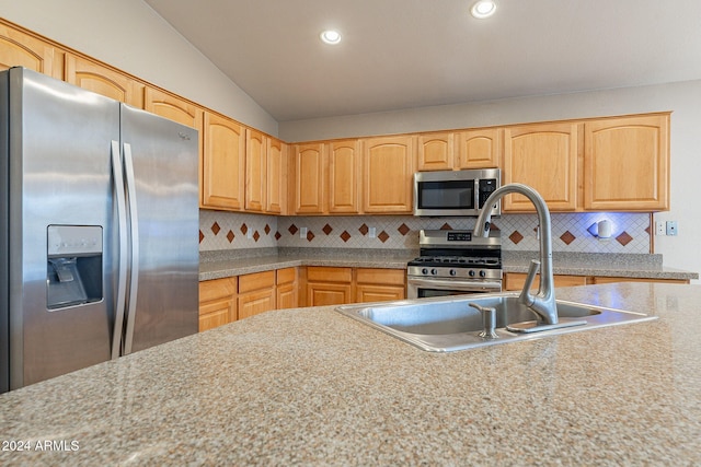 kitchen featuring decorative backsplash, light brown cabinetry, stainless steel appliances, and lofted ceiling