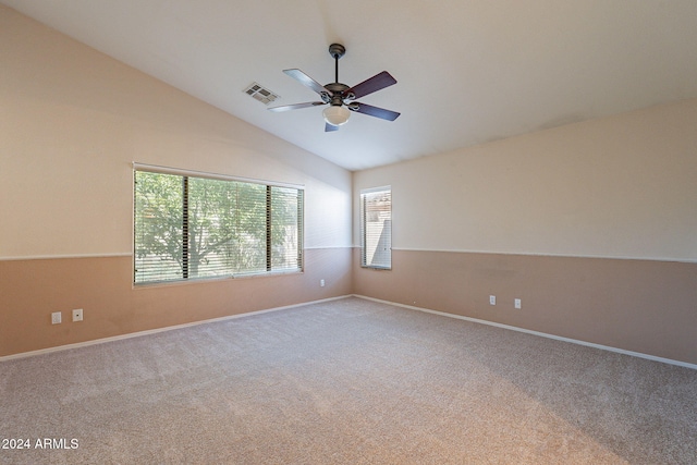 carpeted spare room featuring vaulted ceiling, plenty of natural light, and ceiling fan