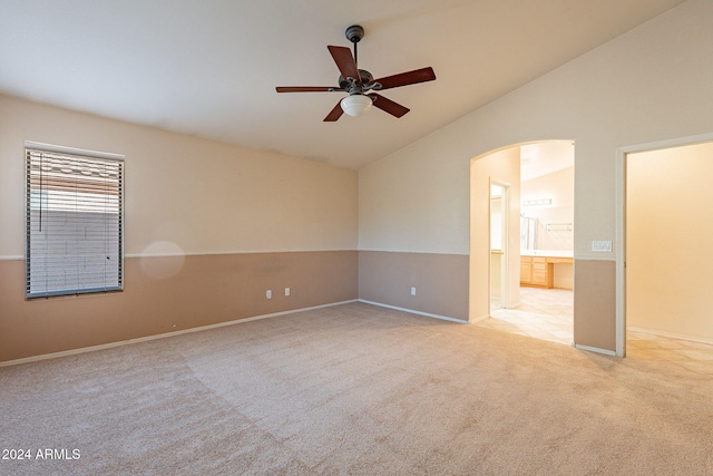 spare room featuring light carpet, ceiling fan, and lofted ceiling