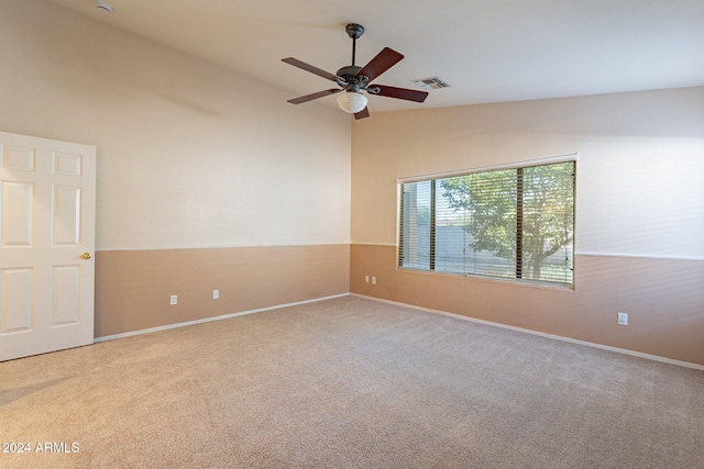 carpeted spare room featuring ceiling fan and lofted ceiling