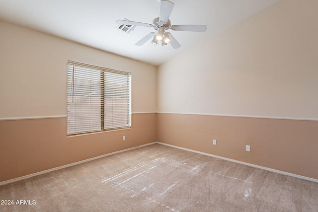 empty room with ceiling fan, light colored carpet, and vaulted ceiling