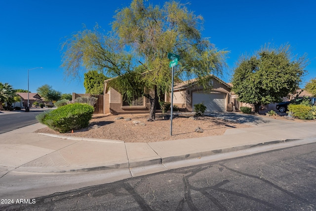 view of property hidden behind natural elements featuring a garage