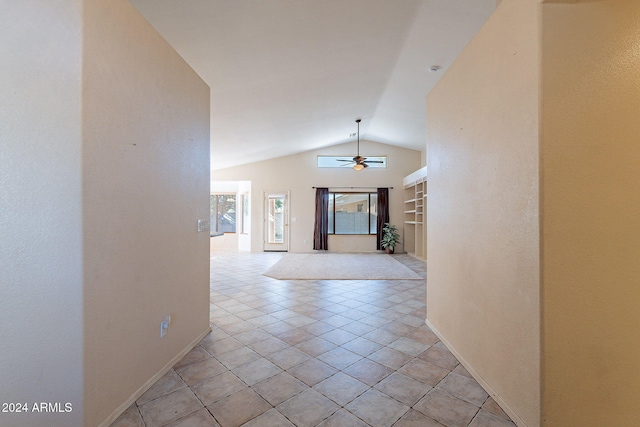 hall featuring light tile patterned floors and vaulted ceiling