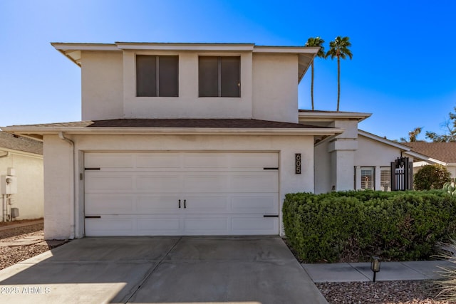 traditional-style home with driveway, an attached garage, and stucco siding