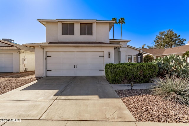 traditional-style house featuring a garage, driveway, and stucco siding