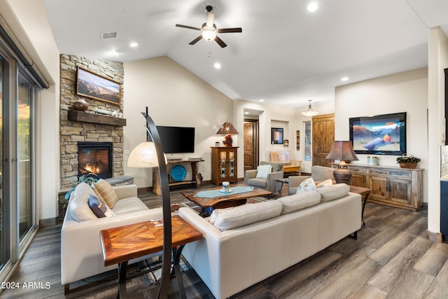 living room featuring lofted ceiling, ceiling fan, a stone fireplace, and dark hardwood / wood-style flooring