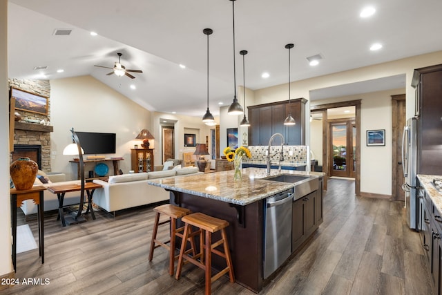 kitchen with a kitchen island with sink, sink, dark brown cabinets, and dark hardwood / wood-style flooring