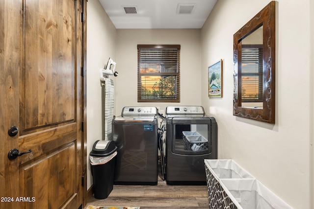 laundry area featuring washing machine and dryer and light hardwood / wood-style floors