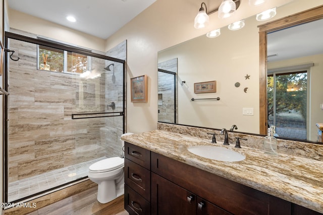 bathroom featuring vanity, toilet, hardwood / wood-style flooring, and walk in shower