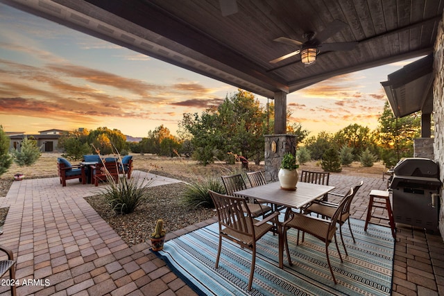 patio terrace at dusk featuring a grill and ceiling fan