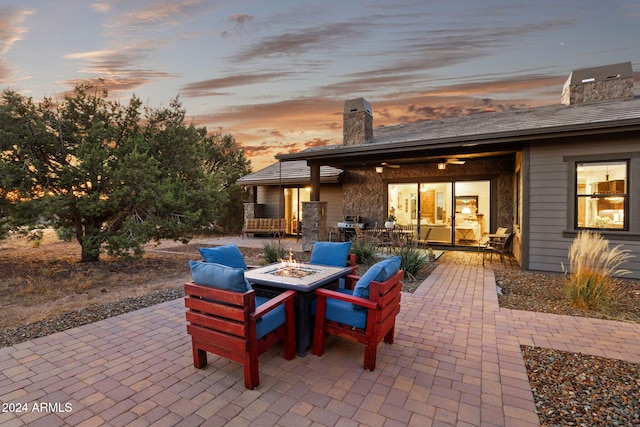 patio terrace at dusk featuring a fire pit