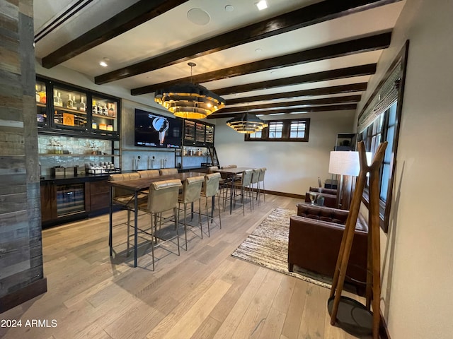 bar featuring light hardwood / wood-style floors, beamed ceiling, an inviting chandelier, and decorative backsplash