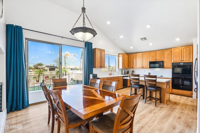 dining area featuring light wood-type flooring, visible vents, high vaulted ceiling, and recessed lighting