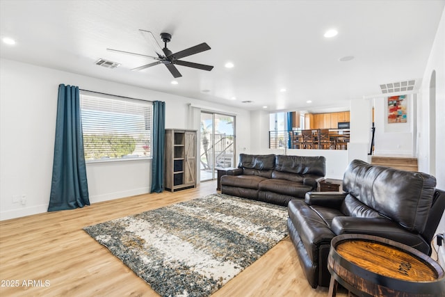 living area with recessed lighting, wood finished floors, visible vents, and baseboards