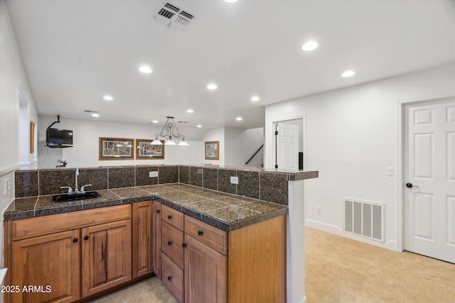 kitchen with tile countertops, light carpet, visible vents, and a sink