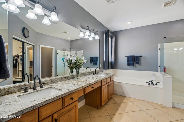 full bath with tile patterned flooring, a stall shower, a garden tub, and a sink