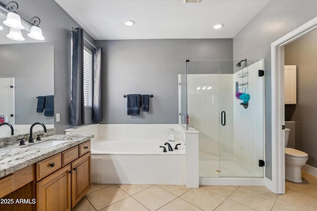 bathroom featuring vanity, a stall shower, tile patterned flooring, a garden tub, and toilet