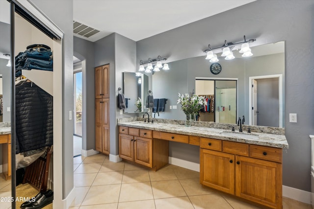 bathroom with double vanity, visible vents, tile patterned flooring, and a sink