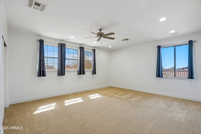 unfurnished room with light colored carpet, visible vents, and baseboards