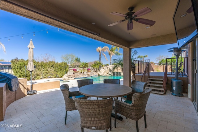 view of patio featuring an outdoor pool, outdoor dining area, a ceiling fan, and fence