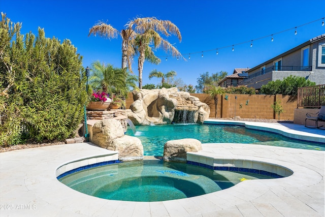 view of swimming pool with a pool with connected hot tub and fence