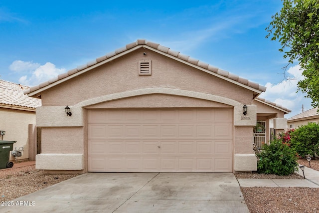 view of front of property with an attached garage, driveway, stucco siding, and a tiled roof