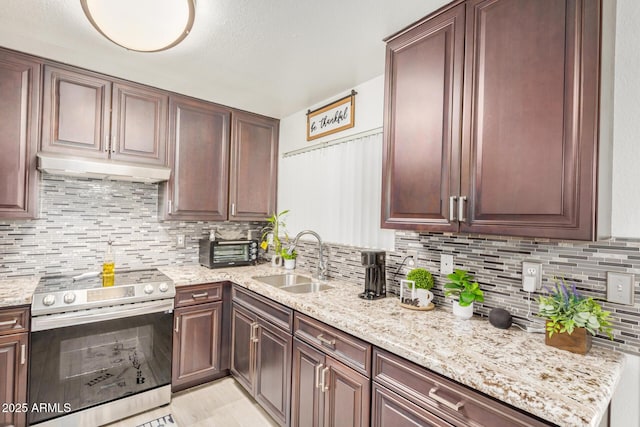 kitchen with stainless steel range with electric stovetop, a sink, under cabinet range hood, tasteful backsplash, and light stone counters