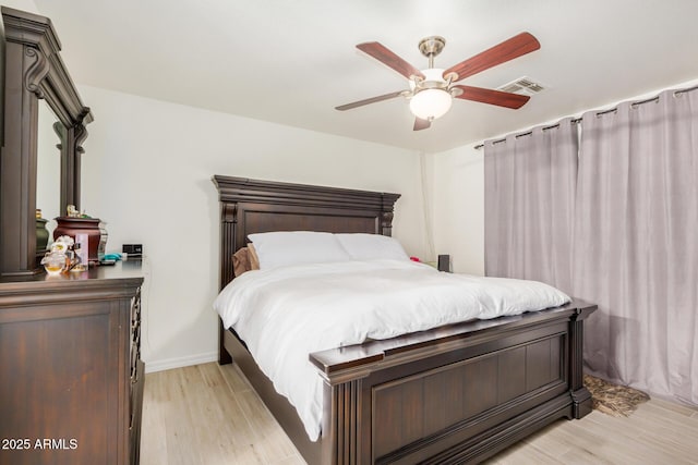 bedroom featuring visible vents, a ceiling fan, and light wood finished floors