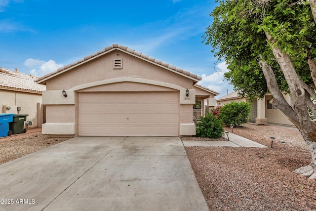 view of front facade featuring driveway, a tiled roof, stucco siding, and a garage