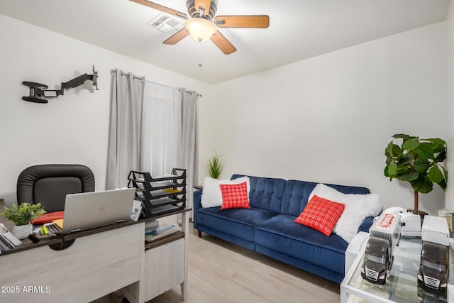 office area featuring light wood finished floors, ceiling fan, and visible vents