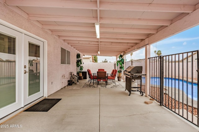 view of patio / terrace with a fenced in pool, area for grilling, a fenced backyard, and outdoor dining area