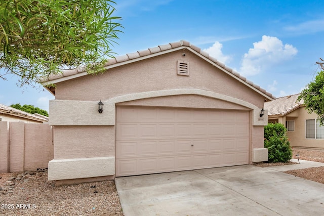 view of front of house featuring stucco siding, a tile roof, concrete driveway, and an attached garage