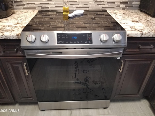 room details featuring light stone countertops, stainless steel range with electric cooktop, dark brown cabinets, and tasteful backsplash